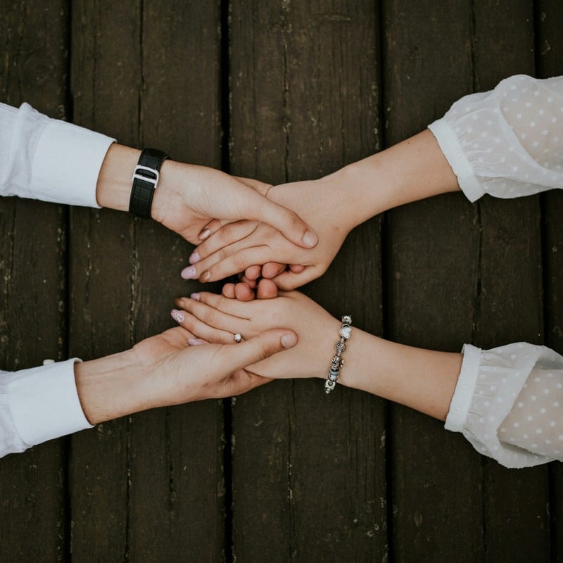 Hands clasped together in support at a CSN meeting